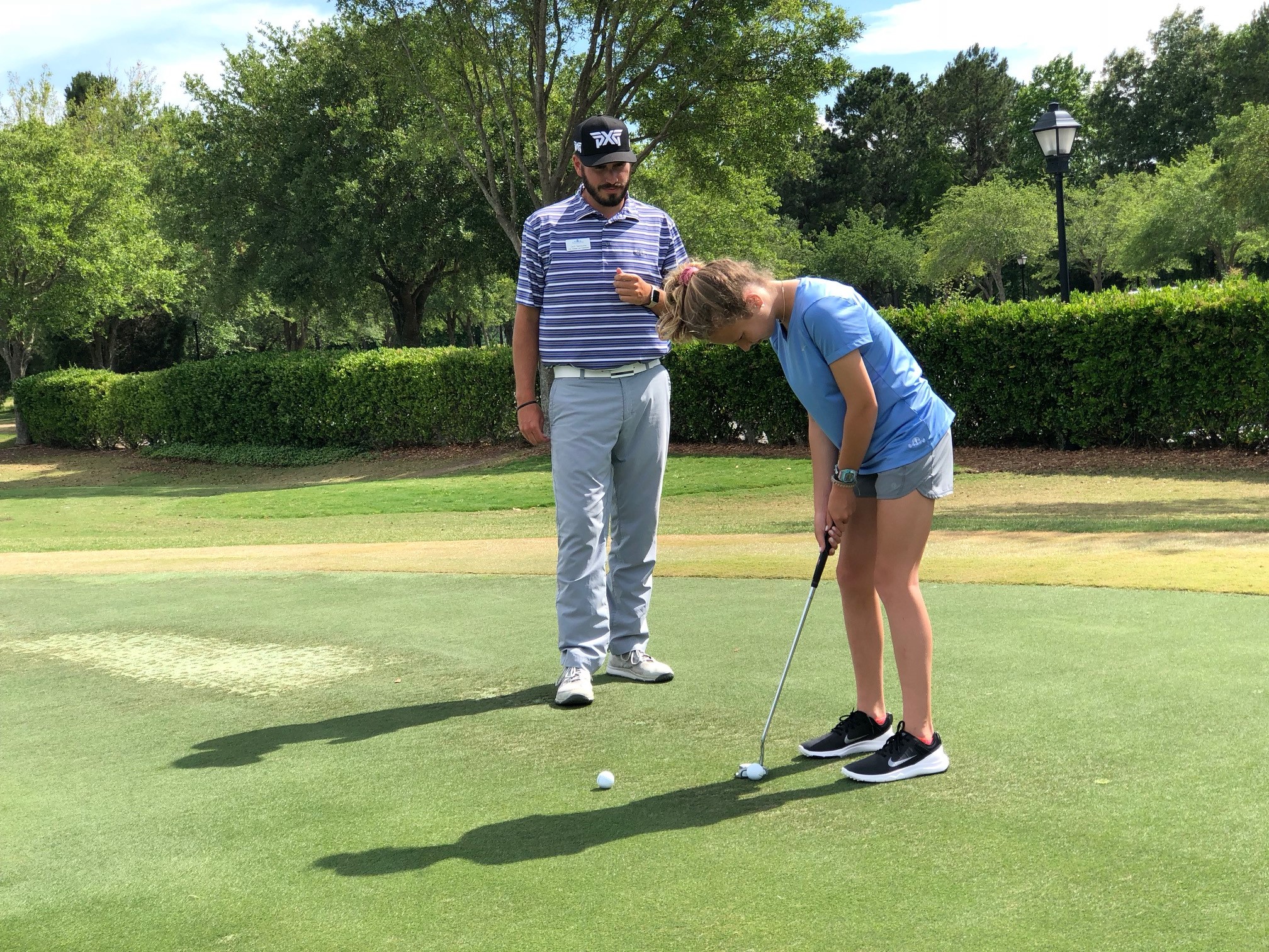 Zach coaching a junior golfer